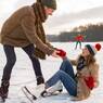Man helping ice skating woman up on icy surface of frozen lake, Cologne, NRW, Germany